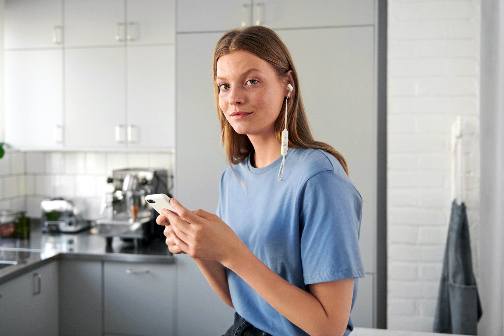 Vrouw met smartphone in keuken