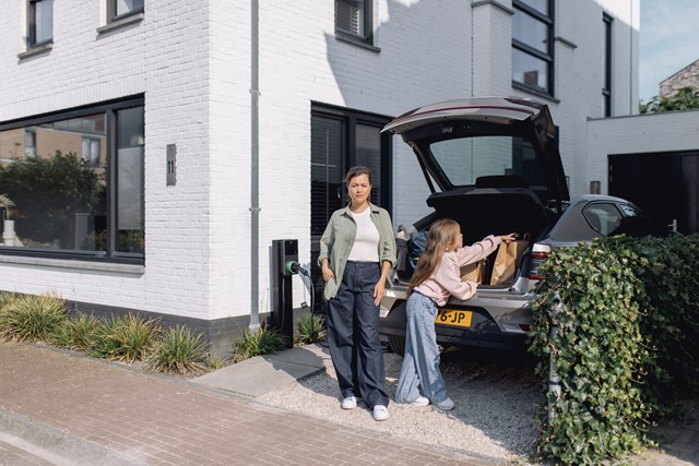 Vrouw en meisje bij auto met laadpaal