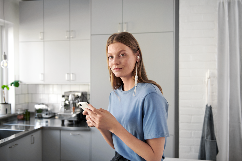 Vrouw in keuken kijkt op haar mobiel | Vattenfall over zonnepanelen