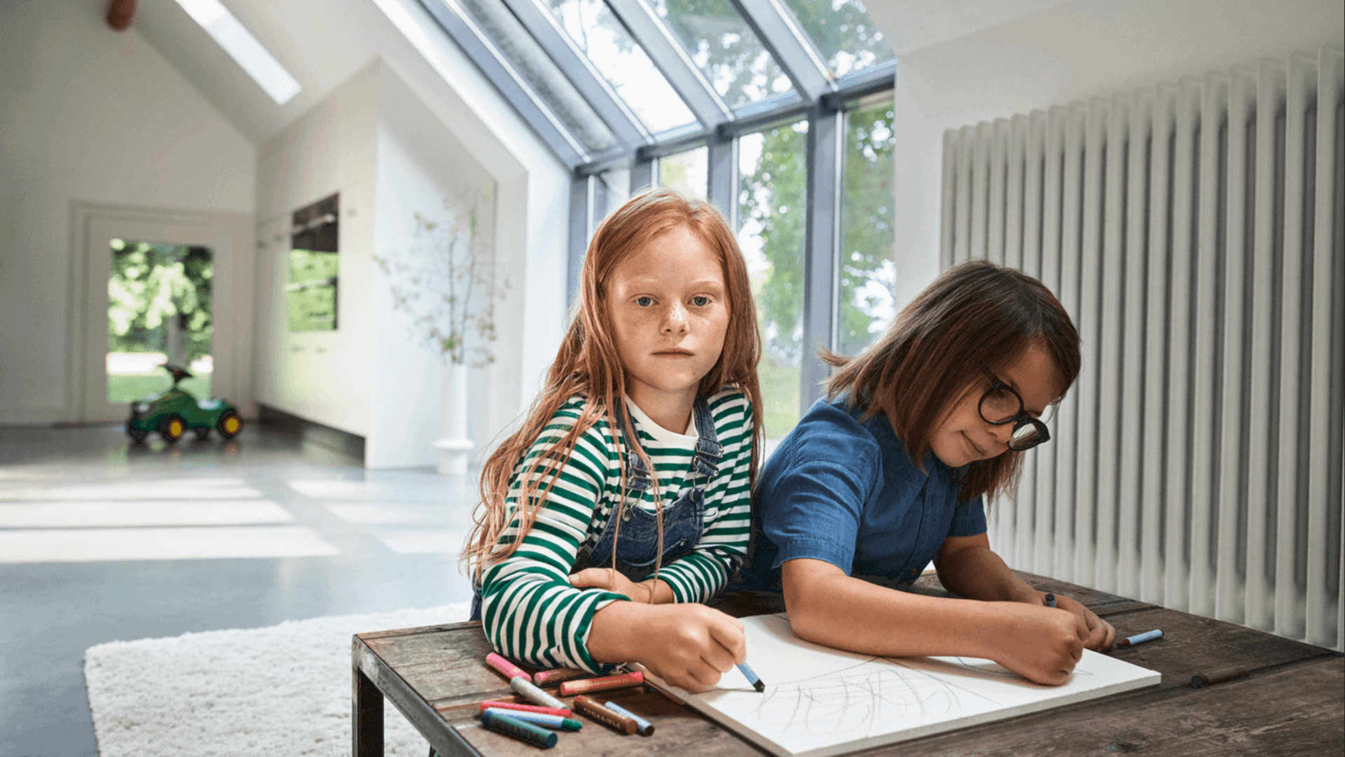 Kinderen zitten naast de verwarming te kleuren