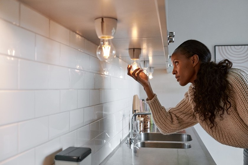 Vrouw draait led-lamp in de keuken