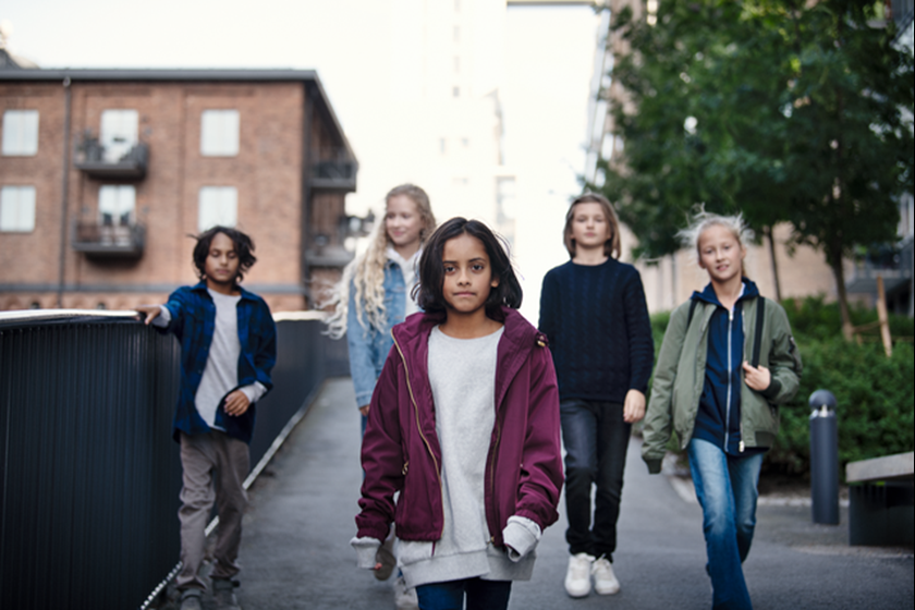 Kinderen lopen door wijk richting de camera