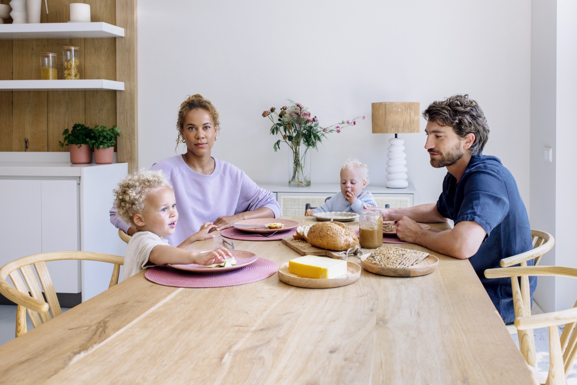 Jong gezin zit aan tafel te ontbijten