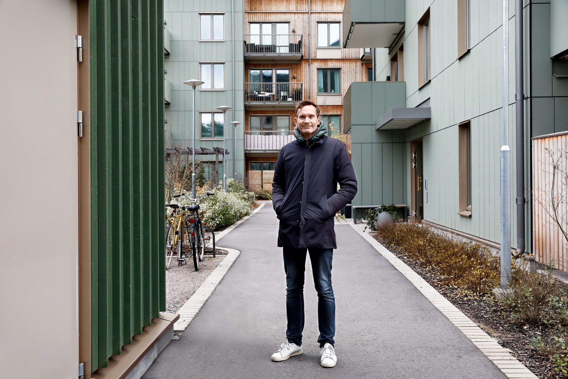 Man staat voor huizenblok verwarm door stadswarmte