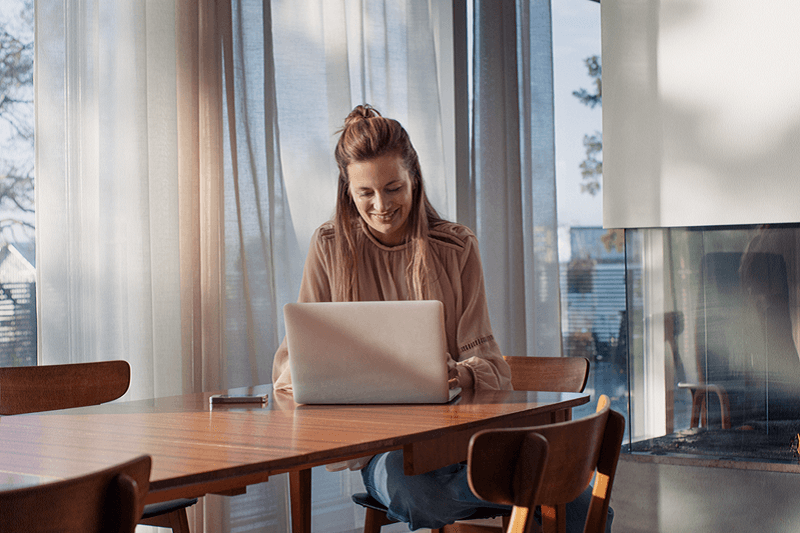 Vrouw werkt achter de laptop aan de eettafel; mag je btw van je energie thuis aftrekken?