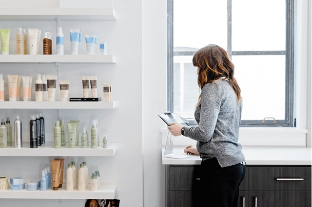 Vrouw in salon (eenmanszaak) checkt inventaris en zakelijke energie