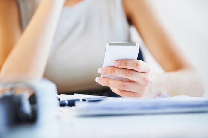 Vrouw die op haar mobiele telefoon kijkt