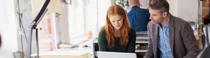 Man en vrouw overleggen voor een computer beeldscherm