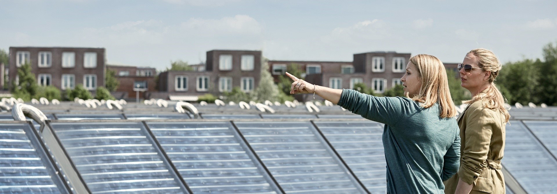 Twee vrouwen staan op een zonnecollectorenveld