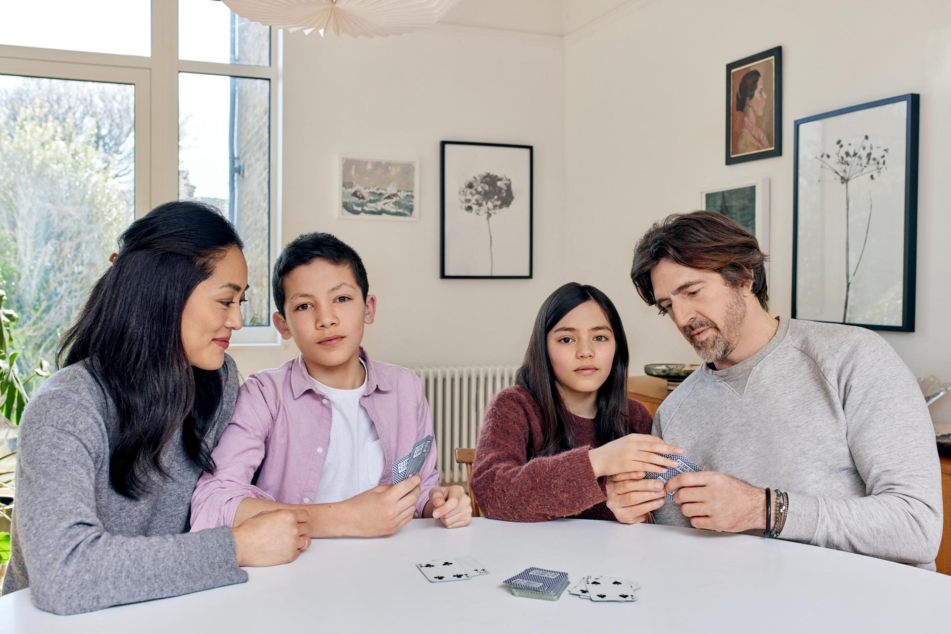 Gezin speelt een spelletje kaarten aan tafel